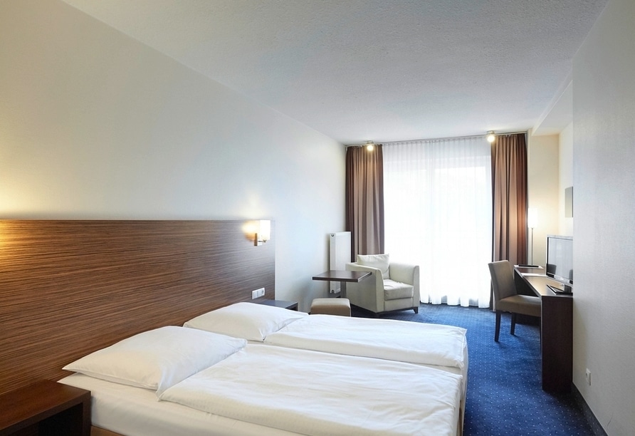 Ein einladendes Doppelzimmer mit zwei Betten im Hotel Silicium, perfekt für den Silvester-Aufenthalt.