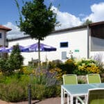 Außenansicht des Hotel Rosenhof mit Gartenbereich, bereit für Silvesterfeiern