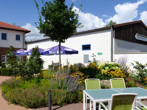 Außenansicht des Hotel Rosenhof mit Gartenbereich, bereit für Silvesterfeiern