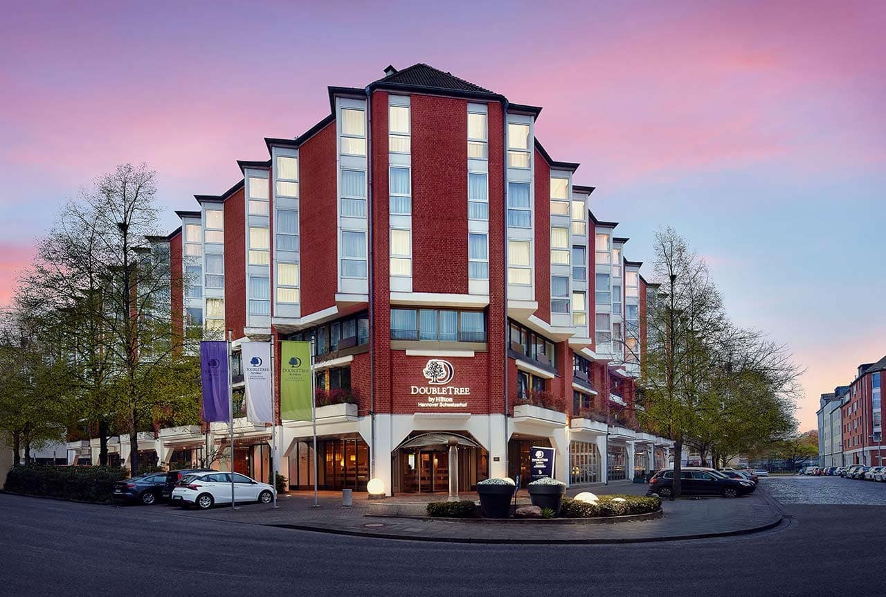 Elegante Außenansicht des DoubleTree by Hilton Hannover Schweizerhof im Abendlicht passend zu Silvester