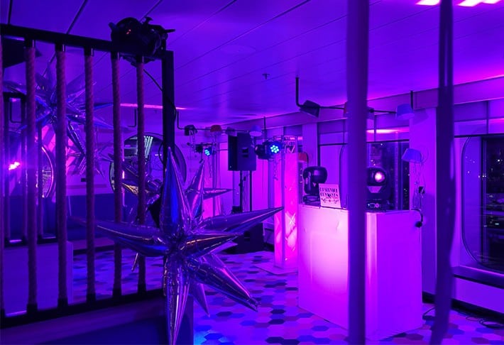 Partyraum mit lila Beleuchtung und Tanzfläche für die Silvesternacht