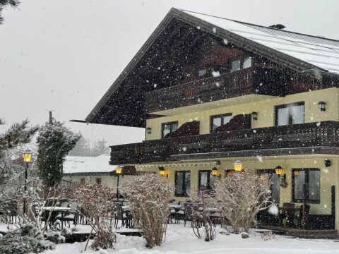 Das DEVA Hotel Fischerwirt in Ruhpolding, umgeben von Schnee, ideal für einen Silvesterurlaub