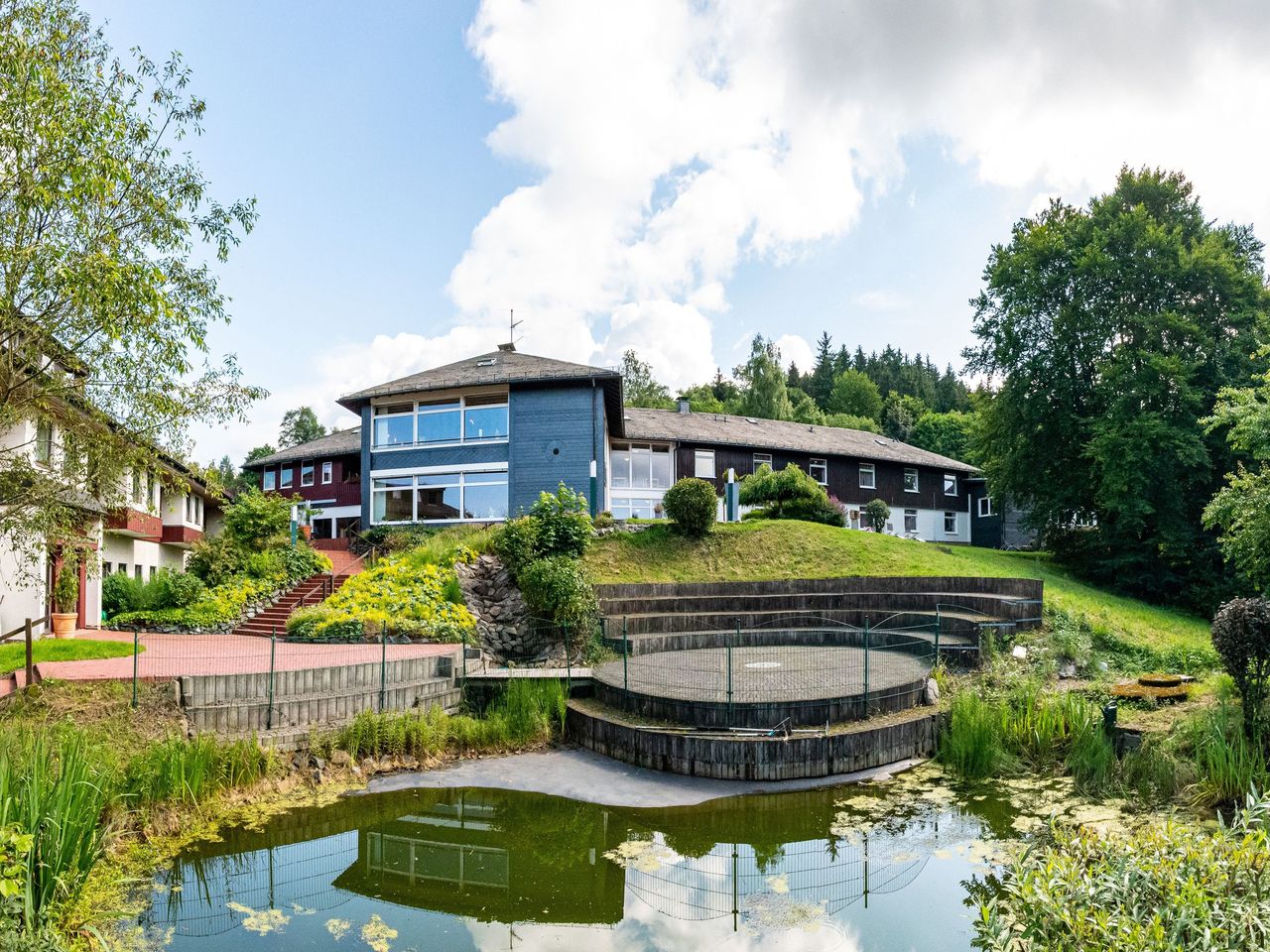 Panorama Hotel Winterberg mit grünem Außenbereich und Teich