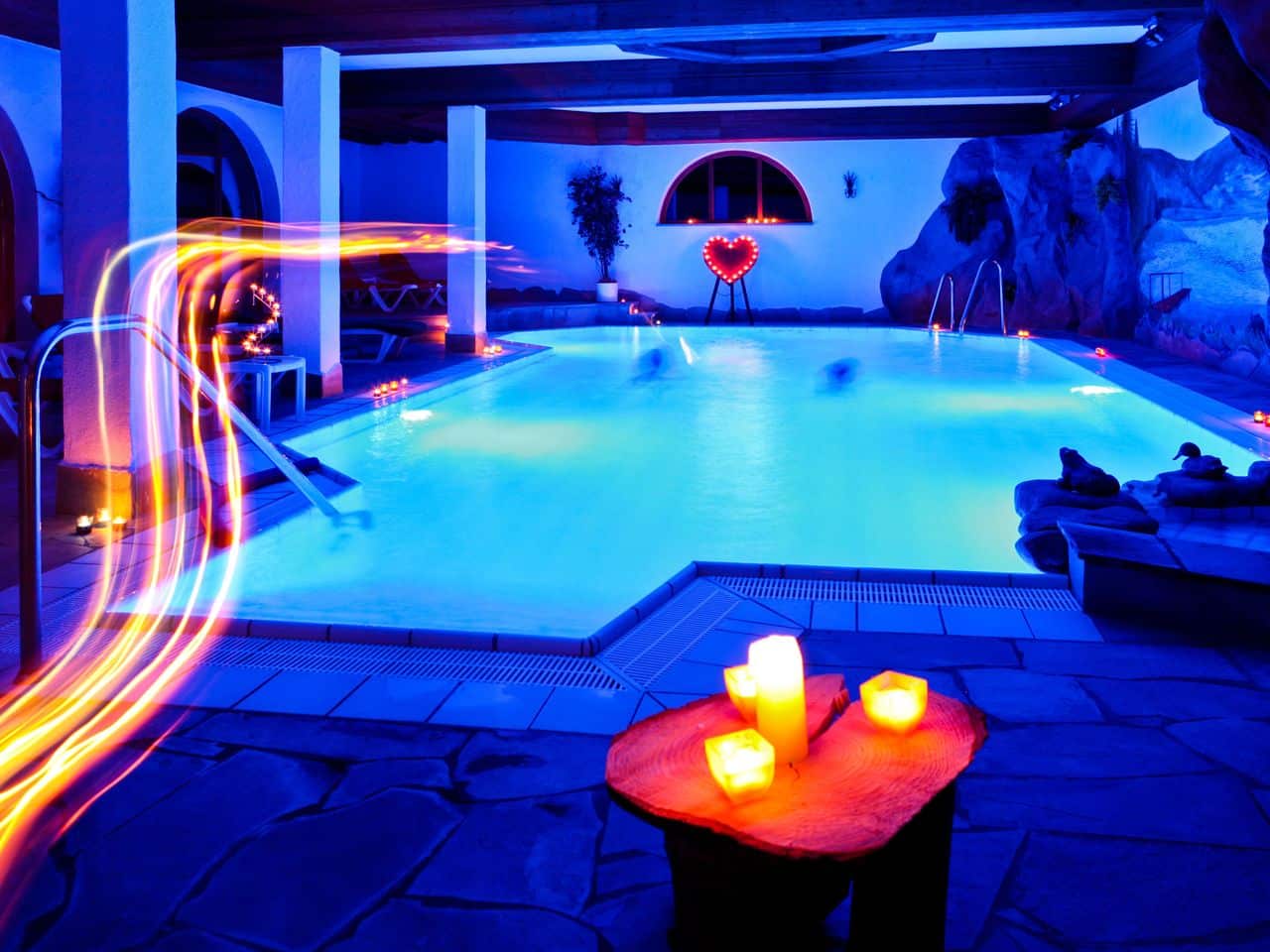 Stimmungsvolles Felsenhallenbad mit Kerzenlicht im Holzschuh's Schwarzwaldhotel, ideal für eine entspannende Silvester-Nacht.