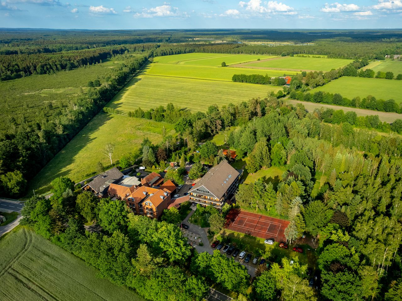 Luftaufnahme vom Hotel Heide Kröpke umgeben von Wiesen und Wäldern zu Silvester