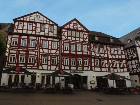 Außenansicht des Hotel Schlemmer Montabaur mit historischem Fachwerk und gemütlicher Terrasse