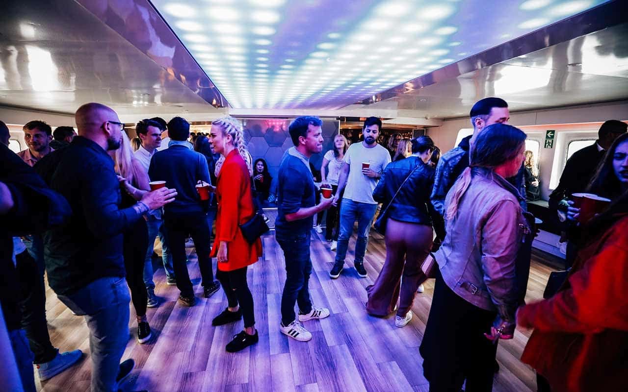 Feiernde Menschen genießen die Silvesterparty im Innenbereich der MS KOI.