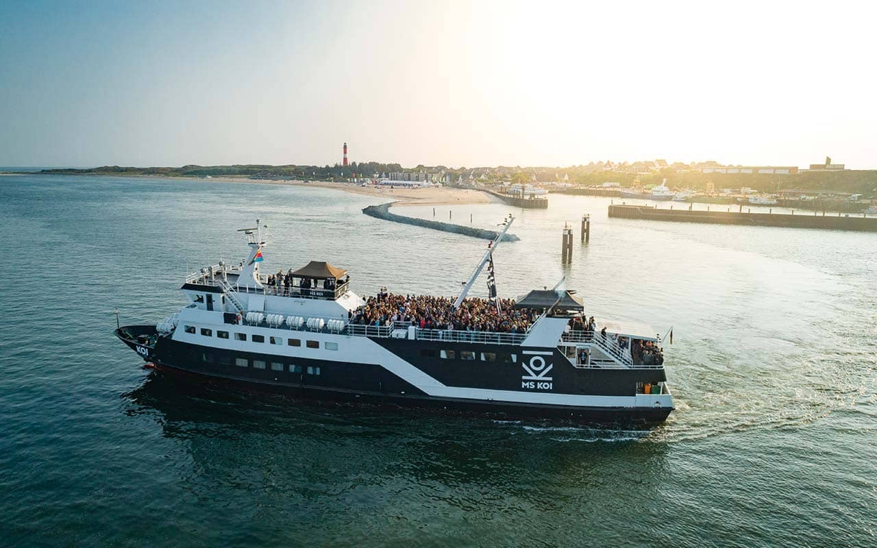 Das Partyschiff MS KOI fährt in den Sonnenuntergang, bereit für die Silvesterfeier.