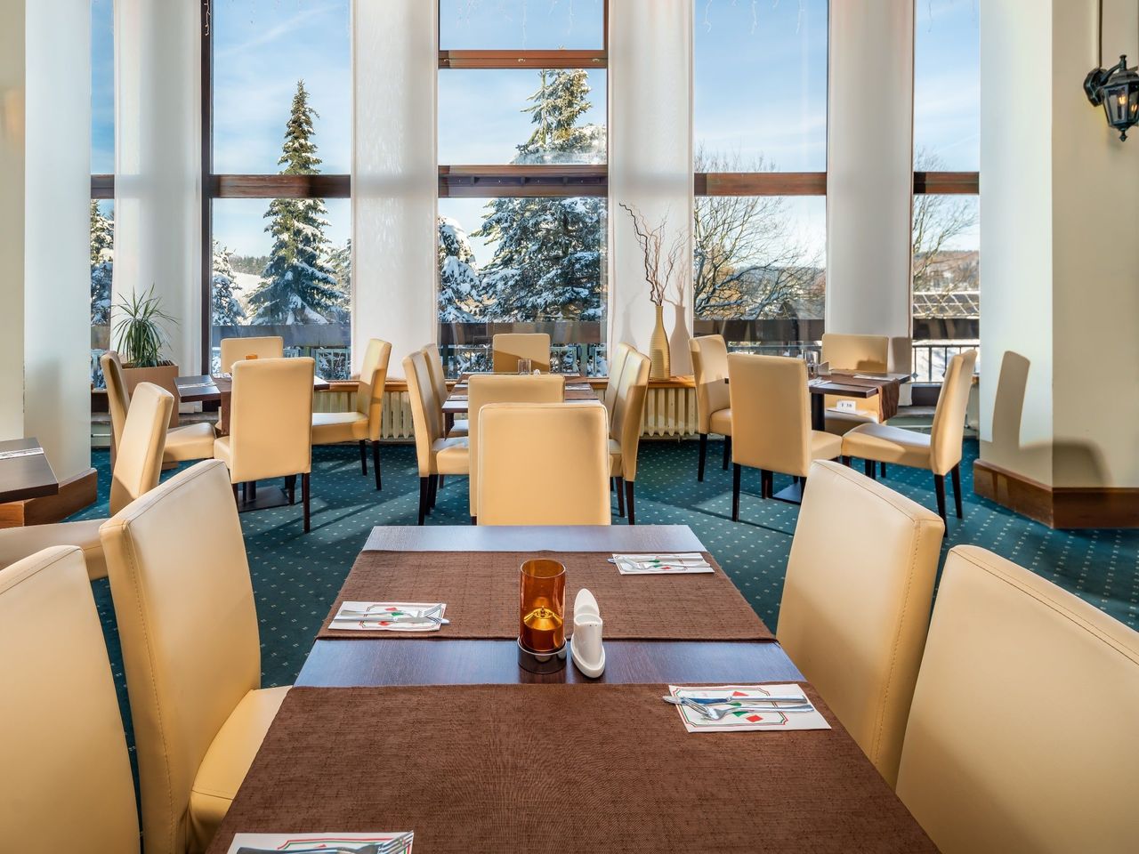 Speisesaal im AHORN Waldhotel Altenberg mit Panoramablick auf die verschneite Winterlandschaft – perfekt für Silvester.