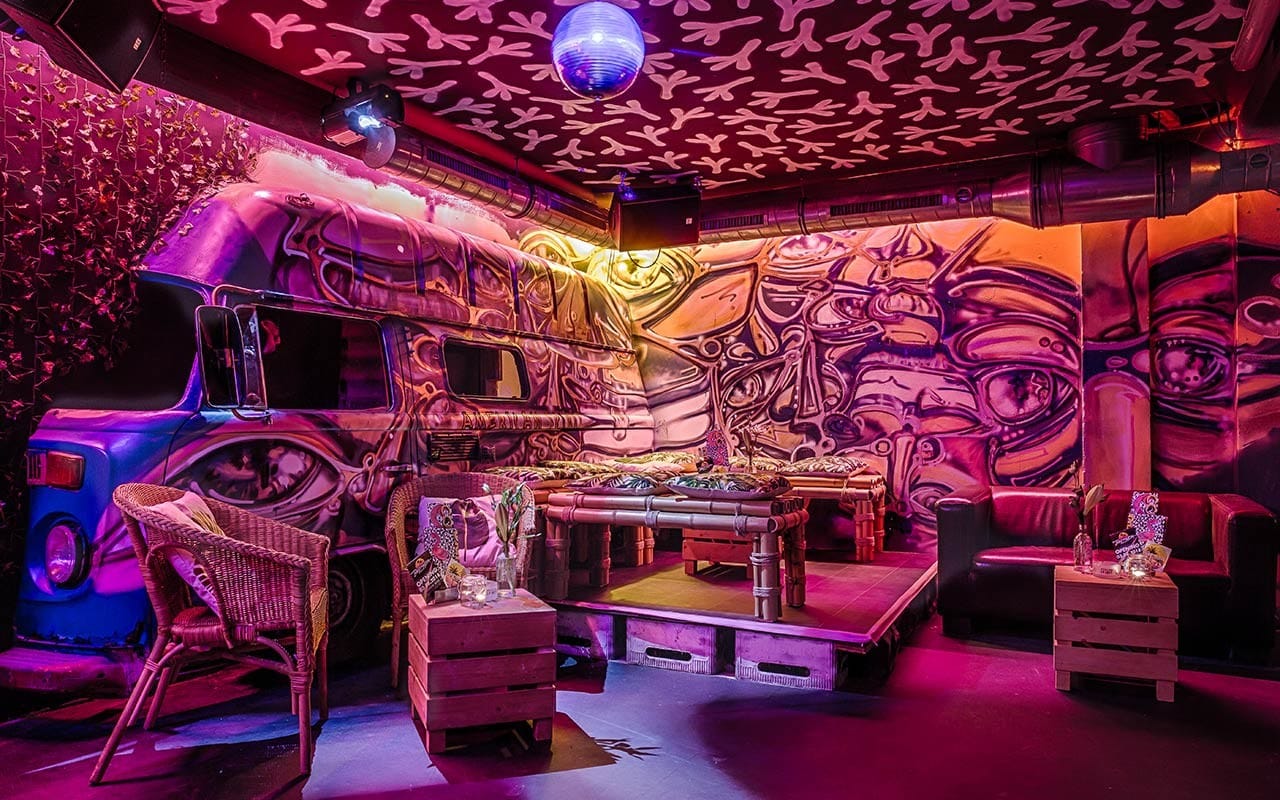 Kreativ gestalteter DJ-Bereich mit Busdeko in der Bermuda Bar für Silvester