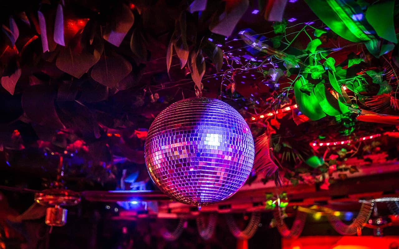 Glitzernde Discokugel unter farbenfrohen Lichtern in der Bermuda Bar für Silvester
