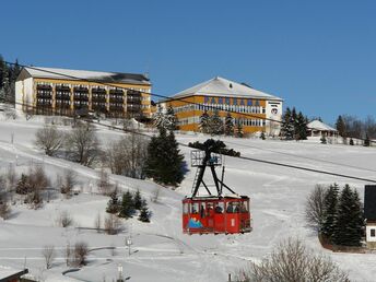 Winterliche Hotelansicht des Best Western Ahorn Hotel Oberwiesenthal mit Seilbahn – Perfektes Ziel für Silvesterurlaub im Erzgebirge