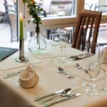 Elegant gedeckter Tisch mit Kerzen und feinem Besteck im Restaurant des Hotel Mainpromenade
