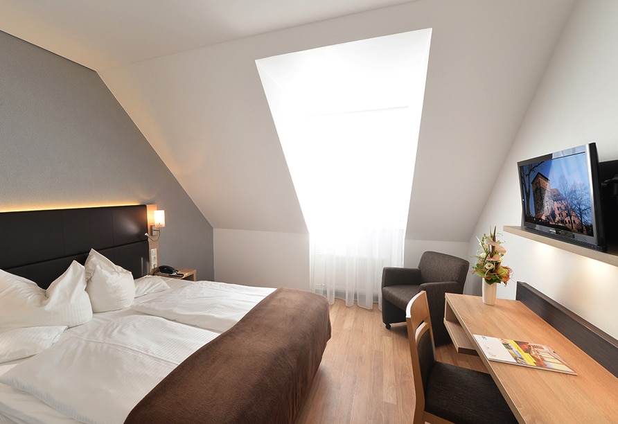 Stilvoll eingerichtetes Doppelzimmer mit Dachfenster im Ringhotel Loew's Merkur