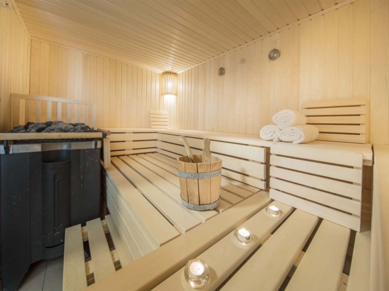 Helle Sauna im HofHotel Krähenberg Grömitz mit Aufgusseimer und Kerzen