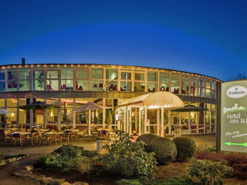 Außenansicht des Hotel Am Wall am Abend mit beleuchteter Terrasse und gemütlichem Ambiente