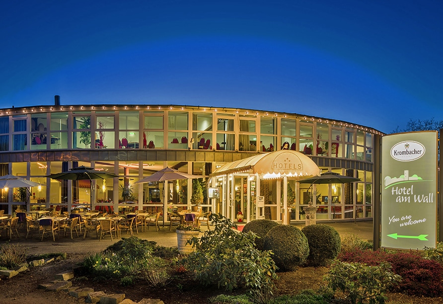 Außenansicht des Hotel Am Wall am Abend mit beleuchteter Terrasse und gemütlichem Ambiente