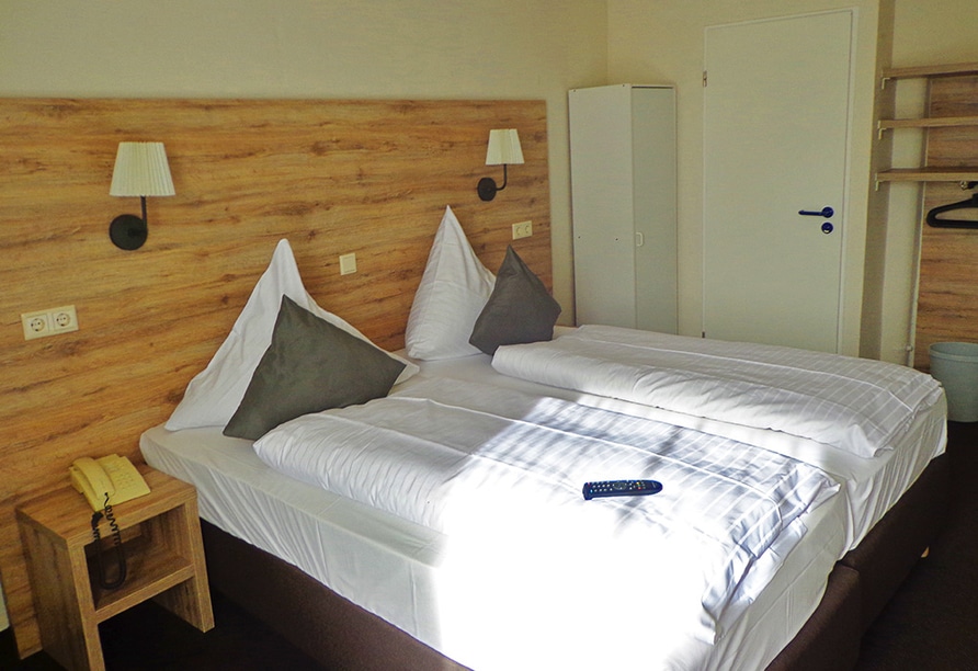 Modern eingerichtetes Doppelzimmer im Hotel Am Wall mit gemütlichem Bett und stilvoller Einrichtung