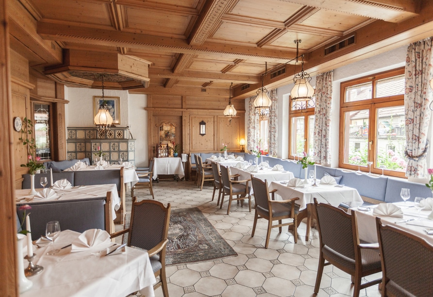 Uriger Gastraum im Hotel Becher mit stilvoll gedeckten Tischen und Kachelofen für eine gemütliche Silvesternacht.
