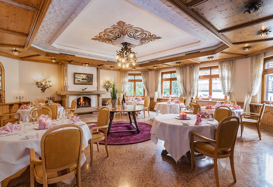 Stilvoll gedeckter Speisesaal im Hotel Becher für Silvester 2025 mit festlicher Dekoration und Kamin.