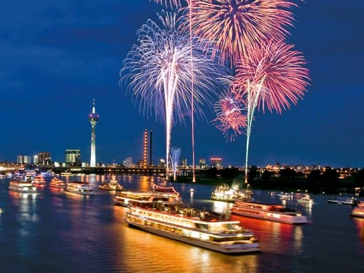 Feuerwerk über dem Rhein in Düsseldorf mit Schiffen bei der Silvesterfeier vom Hotel NH Düsseldorf City