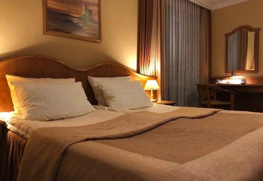 Doppelbett im gemütlichen Hotelzimmer des Hotel Polaris für eine erholsame Silvesternacht