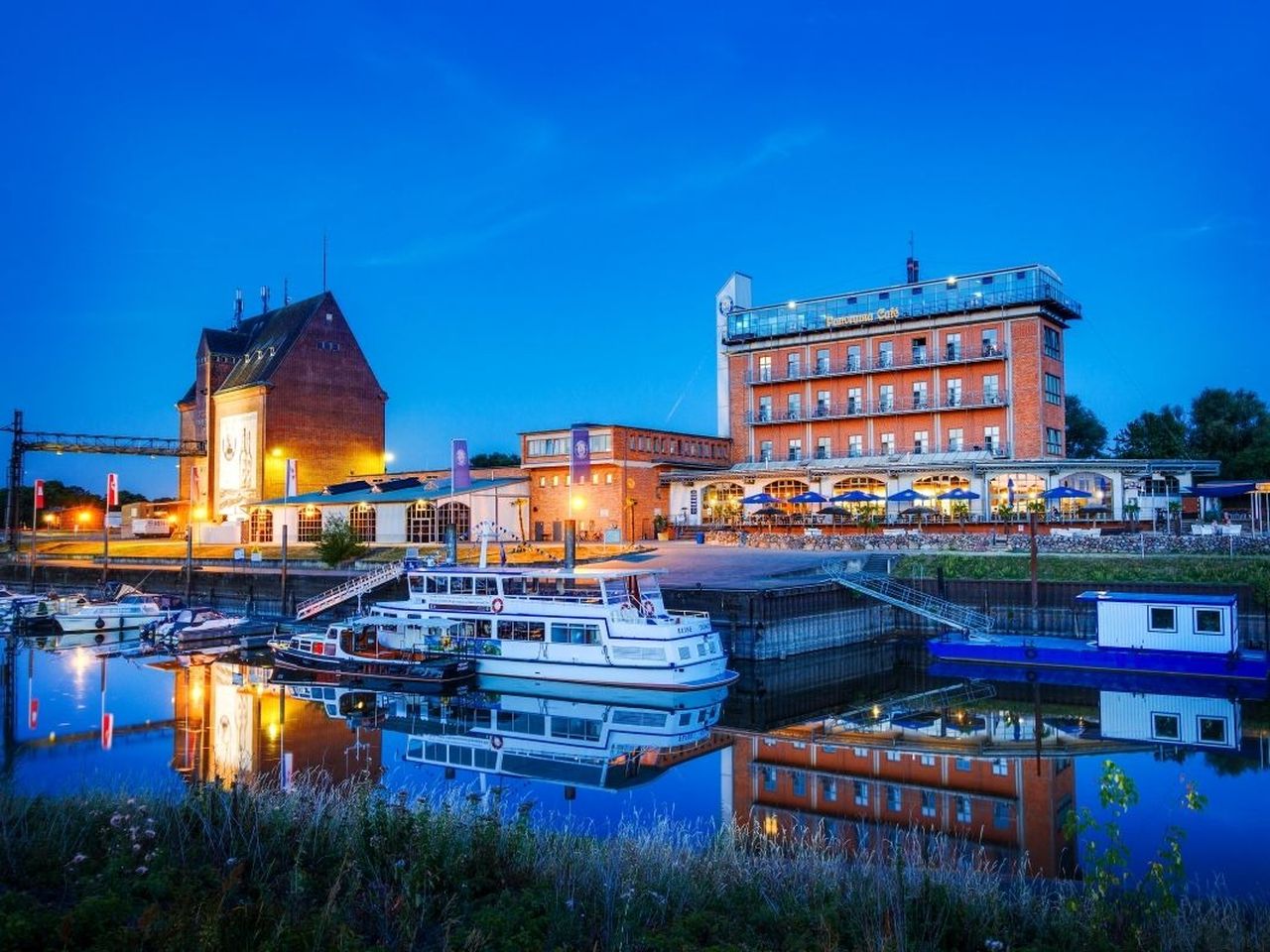 Außenansicht des Hotel Dömitzer Hafen bei Nacht mit Hafenbeleuchtung