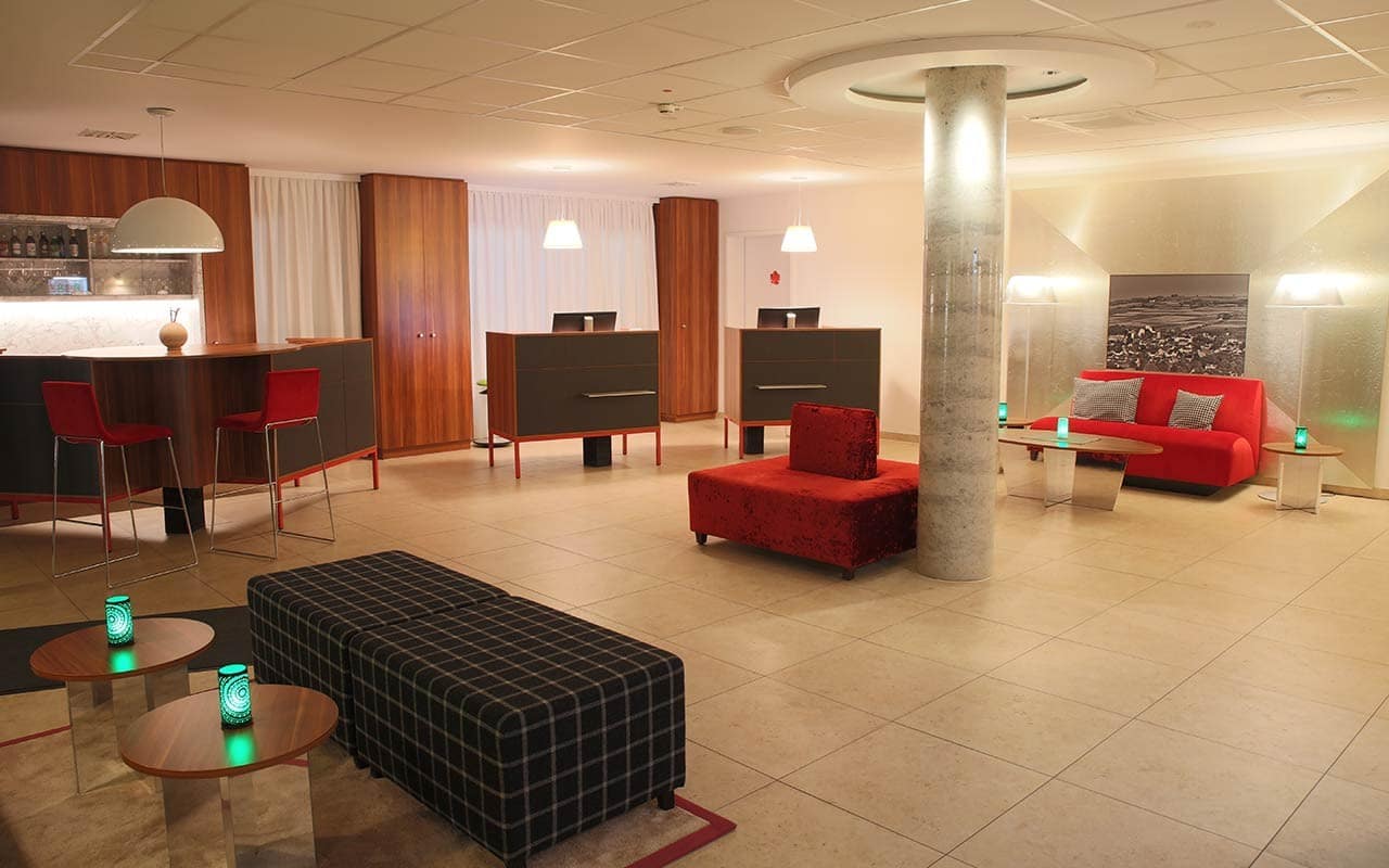 Elegante Lobby des IBB Hotel Ingelheim mit stilvollen Sitzbereichen, ideal für Silvesterbesucher