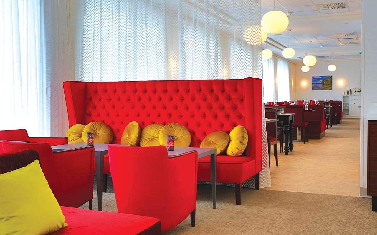 Gemütliche Lounge mit roter Sitzgarnitur im IBB Hotel Ingelheim, ideal für Silvesterfeiern