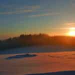 Sonnenuntergang über verschneiter Landschaft zu Silvester im Landgut Stetter