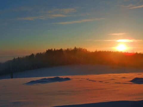 Sonnenuntergang über verschneiter Landschaft zu Silvester im Landgut Stetter