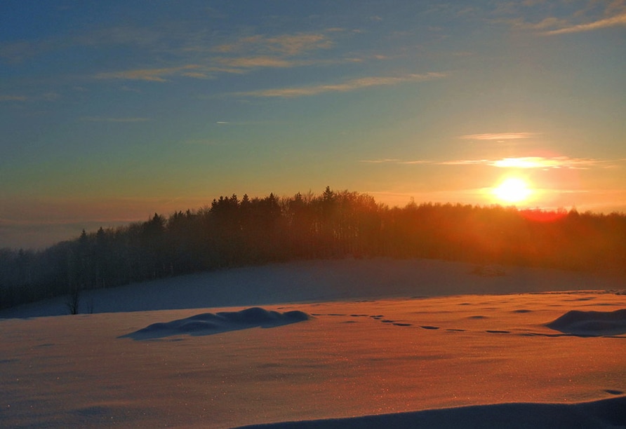 Sonnenuntergang über verschneiter Landschaft zu Silvester im Landgut Stetter