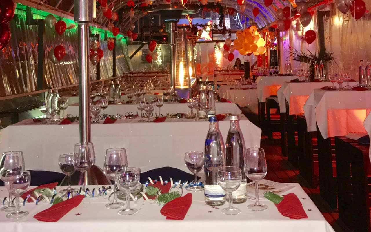 Gäste genießen die Silvesterfeier auf dem Freideck der MS Allegra mit Beleuchtung und DJ