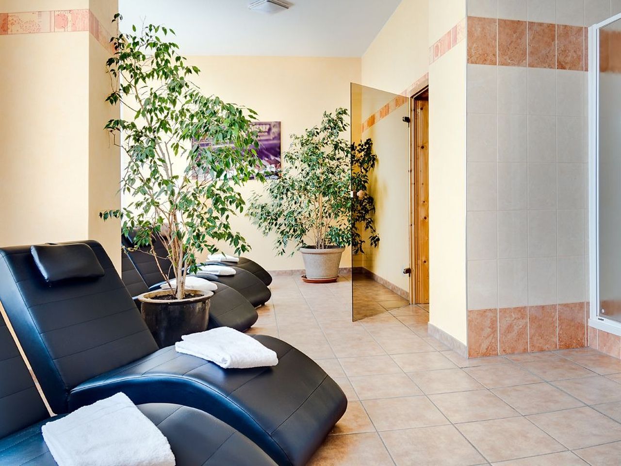 Blick auf die Saunatür und Ruheliegen im Wellnessbereich der Alten Klavierfabrik Meißen