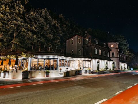 Nachtaufnahme des Schlosshotel Brilon-Wald mit Glasrestaurant