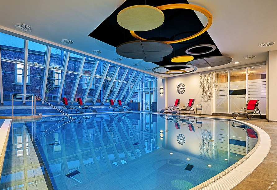 Moderner Wellnessbereich mit Pool und Relaxliegen im Grand Hotel Kaiserhof Victoria zu Silvester