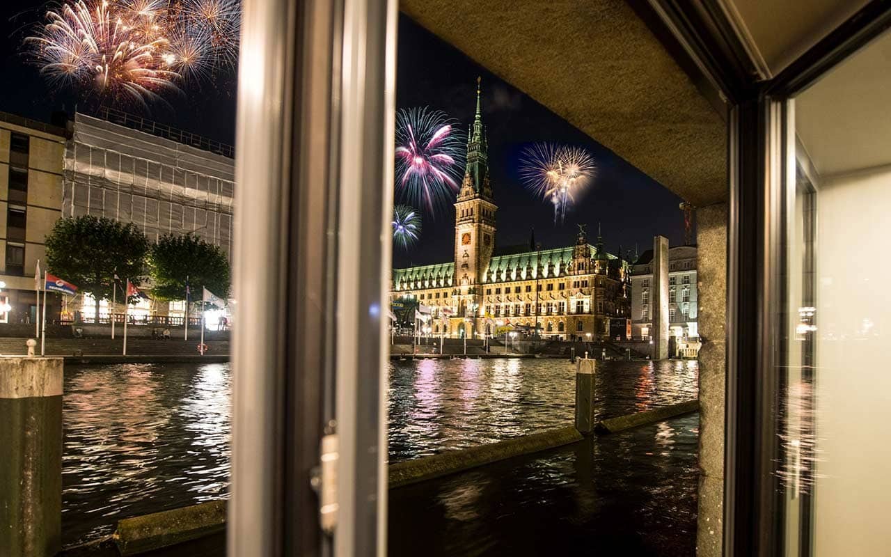 Silvesterfeuerwerk über dem Hamburger Rathaus, gesehen von der Kleinen Alster.