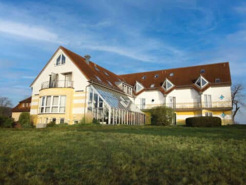 Atemberaubende Aussicht vom Inselhotel Kleiner Bodden mit Sonnenuntergang über der Landschaft – perfekt für Silvester.