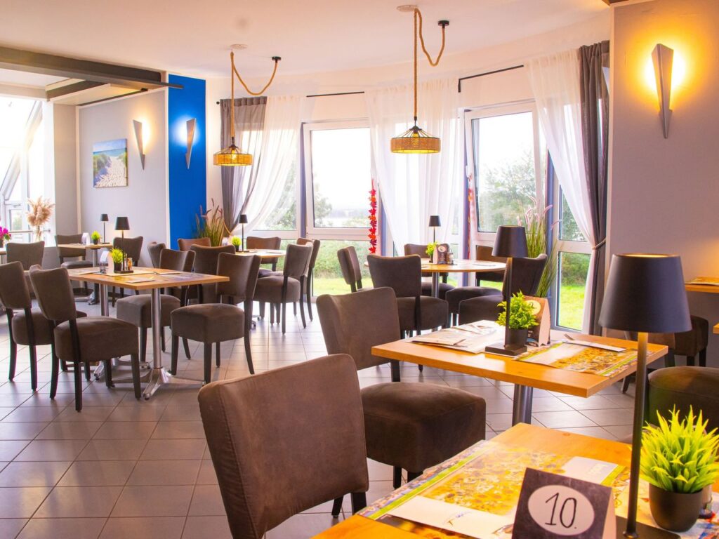 Eleganter Essbereich des Inselhotels Kleiner Bodden mit gedeckten Tischen und Blick ins Grüne – ideal für Silvesterfeiern.