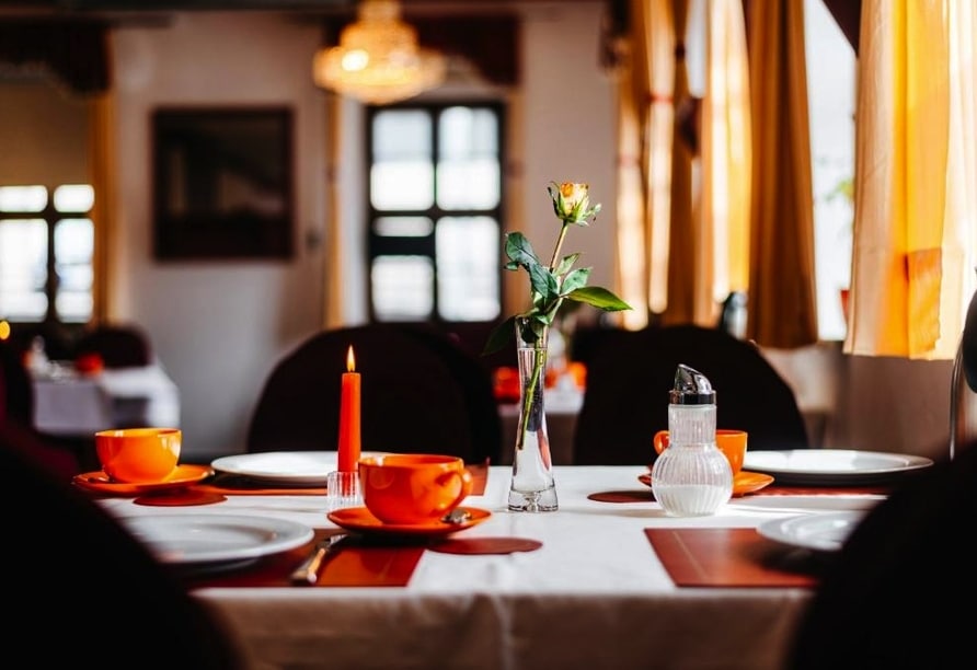 Eleganter Frühstückstisch mit Kerze und Rose im Hotel Brander Hof