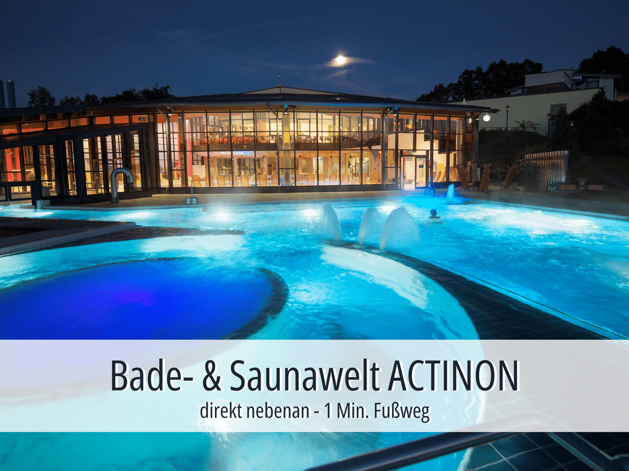 Beleuchteter Außenbereich der Actinon Bade- & Saunawelt bei Nacht
