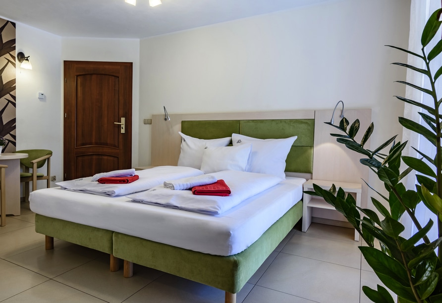 Modern eingerichtetes Zimmer mit grünen Akzenten im Hotel Paula Wellness & Spa, bereit für Silvestergäste