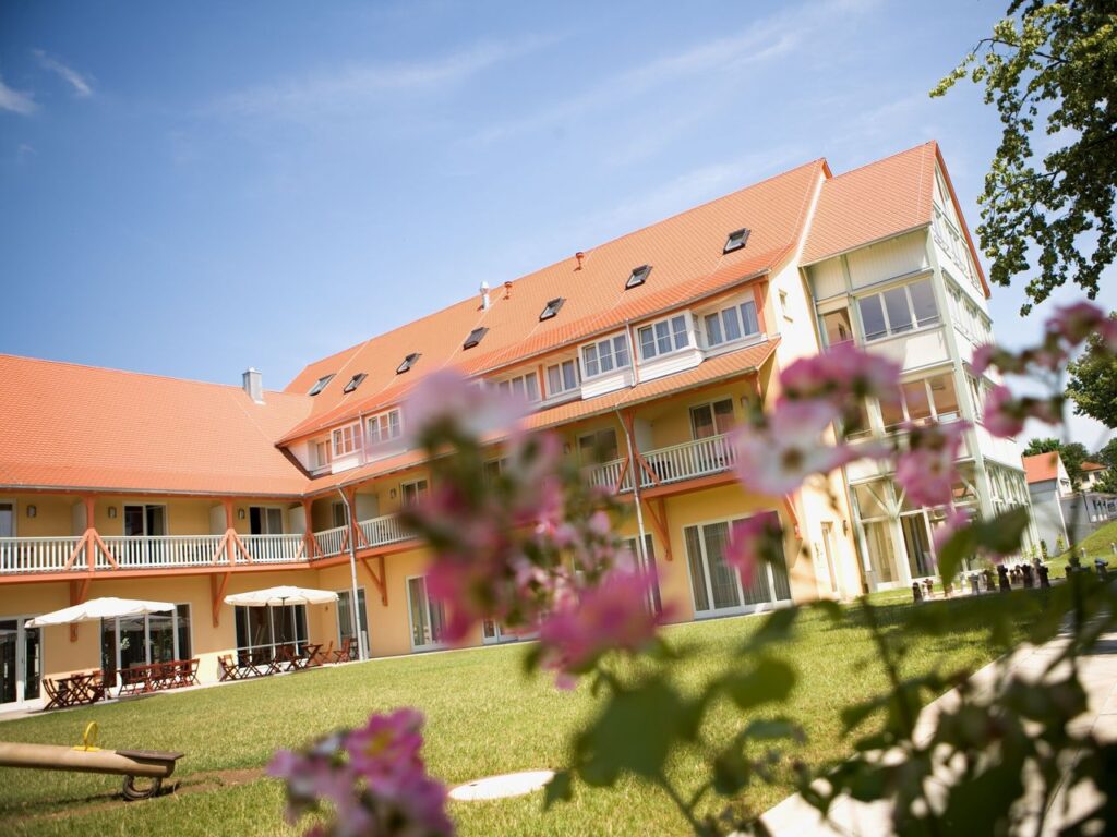 Außenansicht des JUFA Hotel Nördlingen mit Gartenbereich zu Silvester