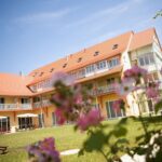 Außenansicht des JUFA Hotel Nördlingen mit Gartenbereich zu Silvester