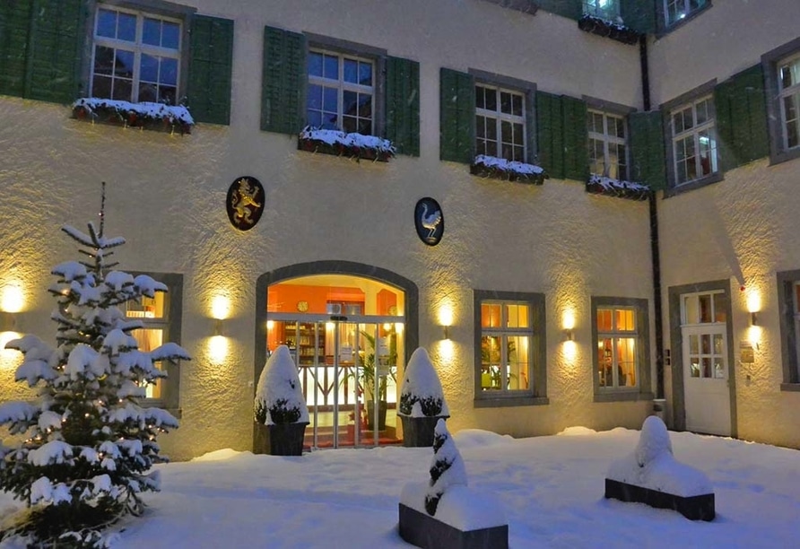 Außenansicht des JUFA Hotel Meersburg im Winter mit Silvesterbeleuchtung