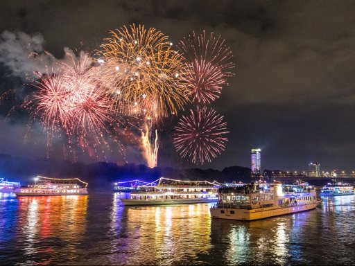Silvesterfeuerwerk über dem Rhein mit beleuchteten Schiffen, IntercityHotel Bonn als Gastgeber