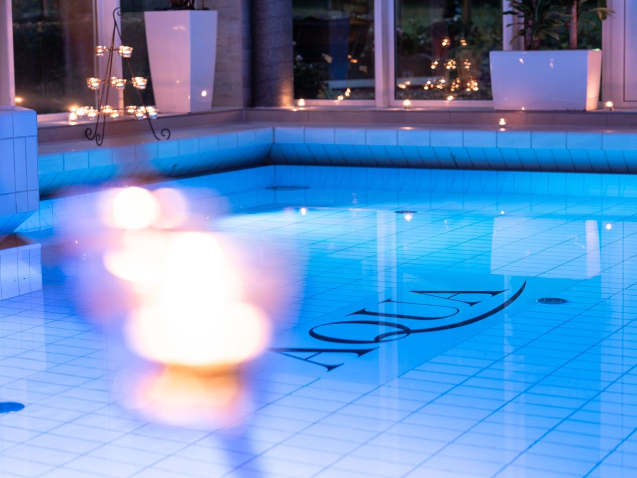Innenpool im AQUA Badebereich des TRIHOTEL Rostock bei Kerzenlicht