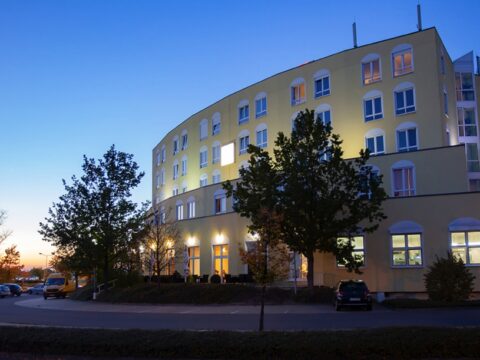 Außenansicht des Hagedorn Hotel Belmondo Leipzig Airport bei Abenddämmerung zu Silvester