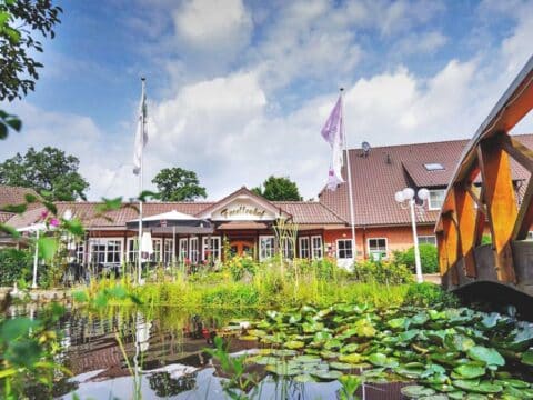 Ringhotel Forellenhof Haupthaus mit Teich und Brücke zur Silvesterzeit