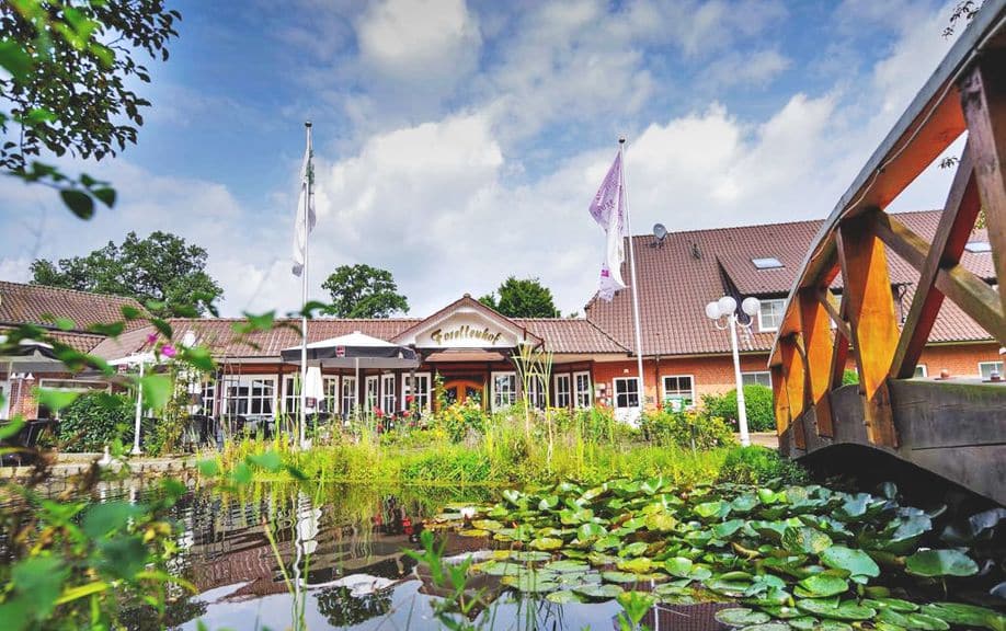 Ringhotel Forellenhof Haupthaus mit Teich und Brücke zur Silvesterzeit